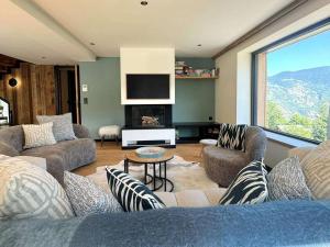 een woonkamer met meubilair en een groot raam bij Chalet spacieux aux Allues, 12 pers., sauna, terrasse - FR-1-180-662 in Les Allues
