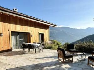 eine Terrasse mit Stühlen und einem Tisch mit Aussicht in der Unterkunft Chalet spacieux aux Allues, 12 pers., sauna, terrasse - FR-1-180-662 in Les Allues
