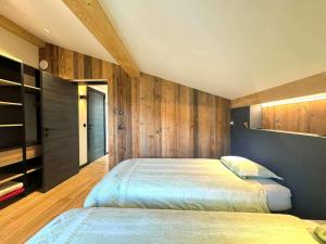twee bedden in een slaapkamer met houten wanden bij Chalet spacieux aux Allues, 12 pers., sauna, terrasse - FR-1-180-662 in Les Allues
