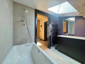 een badkamer met een bad, een wastafel en een spiegel bij Chalet spacieux aux Allues, 12 pers., sauna, terrasse - FR-1-180-662 in Les Allues +15 foto's
