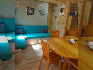a living room with a table and a blue couch at Chalet 50m², 8 personnes, Terrasse - API-1-52-723 in Les Grandes-Ventes