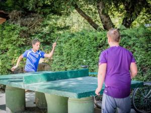 two men standing around a ping pong table at Mobil-home 33m² avec Terrasse - 3 Chambres - API-1-52-682 in Sainte-Eulalie-en-Born