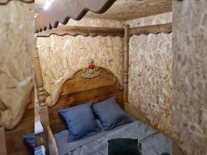 ein Schlafzimmer mit einem Himmelbett mit blauen Kissen in der Unterkunft Chalet 2 chambres avec terrasse aux Grandes-Ventes - API-1-52-534 in Les Grandes-Ventes + 14 Fotos