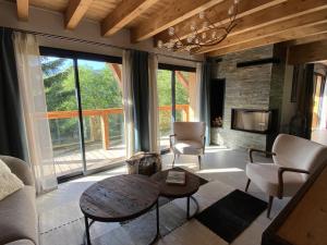 un soggiorno con tavolo, sedie e camino di Chalet 5 Chambres avec Wifi et Parking aux Gets - FR-1-671-299 a Les Gets