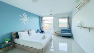 a bedroom with a bed and a blue wall at Turtle Rooms in Bang Tao Beach