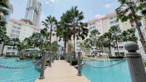 une piscine dans un complexe avec des palmiers et des bâtiments dans l'établissement Blue lagoon seven sea jomtien, à Na Jomtien