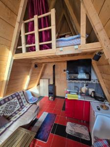 an attic room with a couch and a kitchen at Tri breze in Kolašin