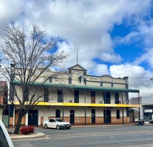 a building with a car parked in front of it at Royal Hotel Coonabarabran in Coonabarabran