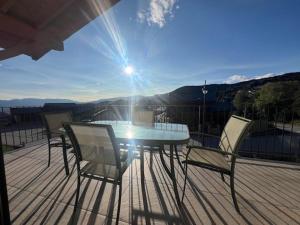 un tavolo e sedie su una terrazza con il sole splendente di Chalet luxueux pour 10 pers. avec parking à Font Romeu - FR-1-703-218 a Font-Romeu-Odeillo-Via
