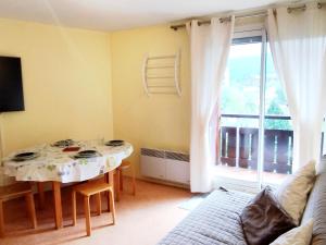 a living room with a table and a large window at 2 Pièces, skis aux pieds, proche commerces avec balcon. Capacité 6 pers, animaux non admis - FR-1-771-11 in Les Adrets