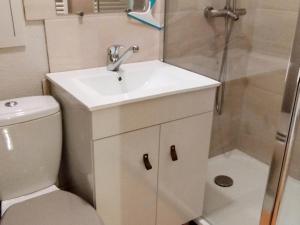 a white bathroom with a sink and a shower at 2 Pièces, skis aux pieds, proche commerces avec balcon. Capacité 6 pers, animaux non admis - FR-1-771-11 in Les Adrets +7 photos