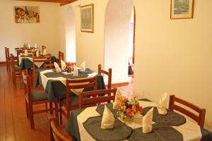 a dining room with tables and chairs with flowers on them at Hotel El Cid Plaza Premium in Tunja