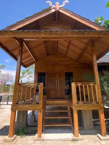 a wooden pavilion with two chairs in front of it at Han's Villa in Sumbawa Besar