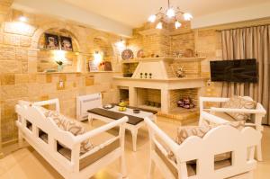 a living room with a table and chairs and a fireplace at Nikolas country villa-anesis family in Kamilari