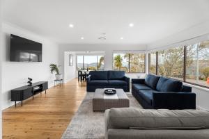 a living room with two blue couches and a table at Montblu at Echo Point in Katoomba