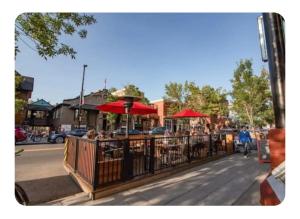 a group of people sitting at a restaurant with red umbrellas at Tania's guest rooms in Calgary