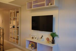 een woonkamer met een flatscreen-tv aan de muur bij Bliss and Bryce Crib 2 at Azure North Pampanga in San Fernando
