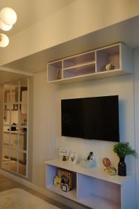 een woonkamer met een flatscreen-tv aan de muur bij Bliss and Bryce Crib 2 at Azure North Pampanga in San Fernando