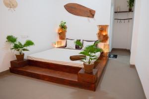 a bedroom with a wooden bed with potted plants at AmoreBay in Mirissa +29 photos
