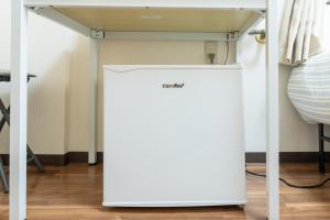 a white refrigerator under a table in a room at Kanamachi INN A-1 in Tokyo