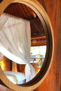 a round window with a bed in a room at Private Pool Retreat With Two Villas, Two Kitchens, Two Bathrooms, Perfect for Families and Friends Traveling Together in Ubud