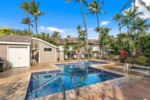 a swimming pool in front of a house with palm trees at Premier Collection at Grand Champions Wailea - Limited-Time Half Off in Wailea