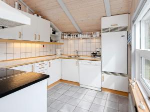 a kitchen with white cabinets and a refrigerator at 4 star holiday home in Henne in Henne Strand