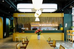 a restaurant with a table and chairs and a counter at Dengba Inn - Qingdao Taidong Pedestrian Street Branch in Qingdao