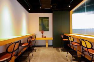 a bar with chairs and a table in a room at Dengba Inn - Qingdao Taidong Pedestrian Street Branch in Qingdao