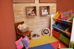 une salle de jouets avec un mur en briques et des poupées dans l'établissement Hotel Do Lago, à Guaíra