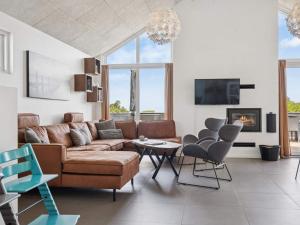a living room with a brown couch and chairs at 5 star holiday home in Glesborg in Glesborg