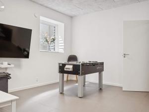 a table with a chair in a white room at 20 person holiday home in Glesborg in Glesborg +26 photos