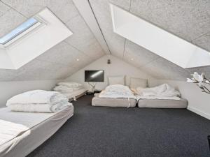 a attic bedroom with two beds and skylights at 5 star holiday home in Glesborg in Glesborg