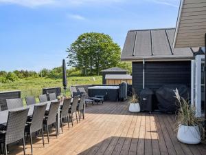 a deck with chairs and a table and a grill at 20 person holiday home in Glesborg in Glesborg