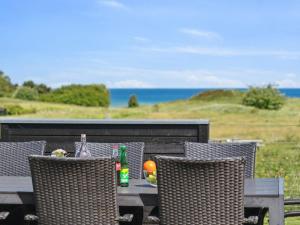 a table with chairs and a bottle and fruit on it at 20 person holiday home in Glesborg in Glesborg +103 photos
