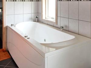 a white bath tub in a bathroom with a window at 7 person holiday home in Fanø-By Traum in Fanø +28 photos