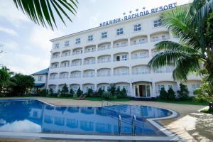 un hôtel avec une piscine devant dans l'établissement Hoa Binh - Rach Gia Resort, à Rạch Giá
