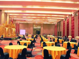 TanjungbungaにあるGammara Hotel Makassarの黄色いテーブルと椅子、スクリーンのある宴会場 +266枚の写真