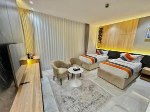 a hotel room with two beds and a couch at Diamond Palm Hotel & Resort in Al Burj