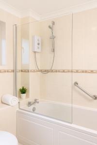 a bathroom with a tub and a shower at Modern 3-Bedroom Home with Free Parking for Family, Contractors and Tourists! in Sittingbourne