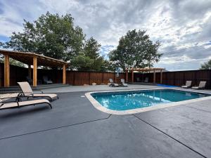 a swimming pool with two chairs and a pavilion at THE CW HOUSE in Claude