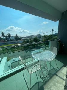 a glass table and chairs on a balcony at Pangkor Villa 16 Homestay 4Rooms 3Bathroom Free WIFI & Karaoke in Pangkor