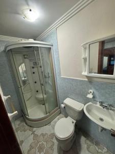 Un baño con ducha, inodoro y lavabo. en Spacious 6 bedroom home, en Cuenca 12 fotos más