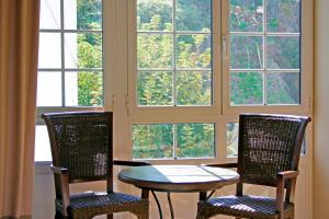 two chairs and a table in front of a window at Hotel La Colmena in Luarca