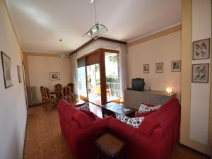 a living room with a red couch and a table at Spacious Retreat in Cannero in Cannero Riviera