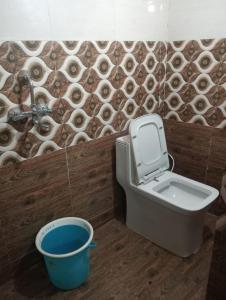 a bathroom with a toilet and a bucket at Maa Vaishno Guest House in Varanasi