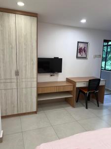 una camera da letto con una scrivania e una TV e una scrivania e una sedia di Destiny Inn Homestay a Bukit Mertajam Altre 3 foto