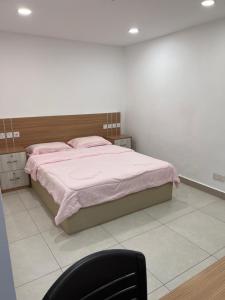 una camera con letto, lenzuola rosa e sedia di Destiny Inn Homestay a Bukit Mertajam