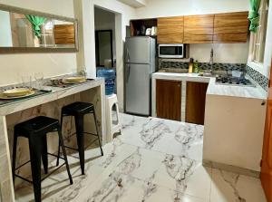 a kitchen with marble counter tops and a refrigerator at La Puerta Blanca #2 in Puerto Vallarta