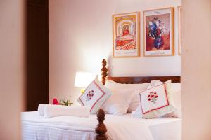a bedroom with a bed with white sheets and pillows at Aurora Luxe Residence in Jaipur +40 photos